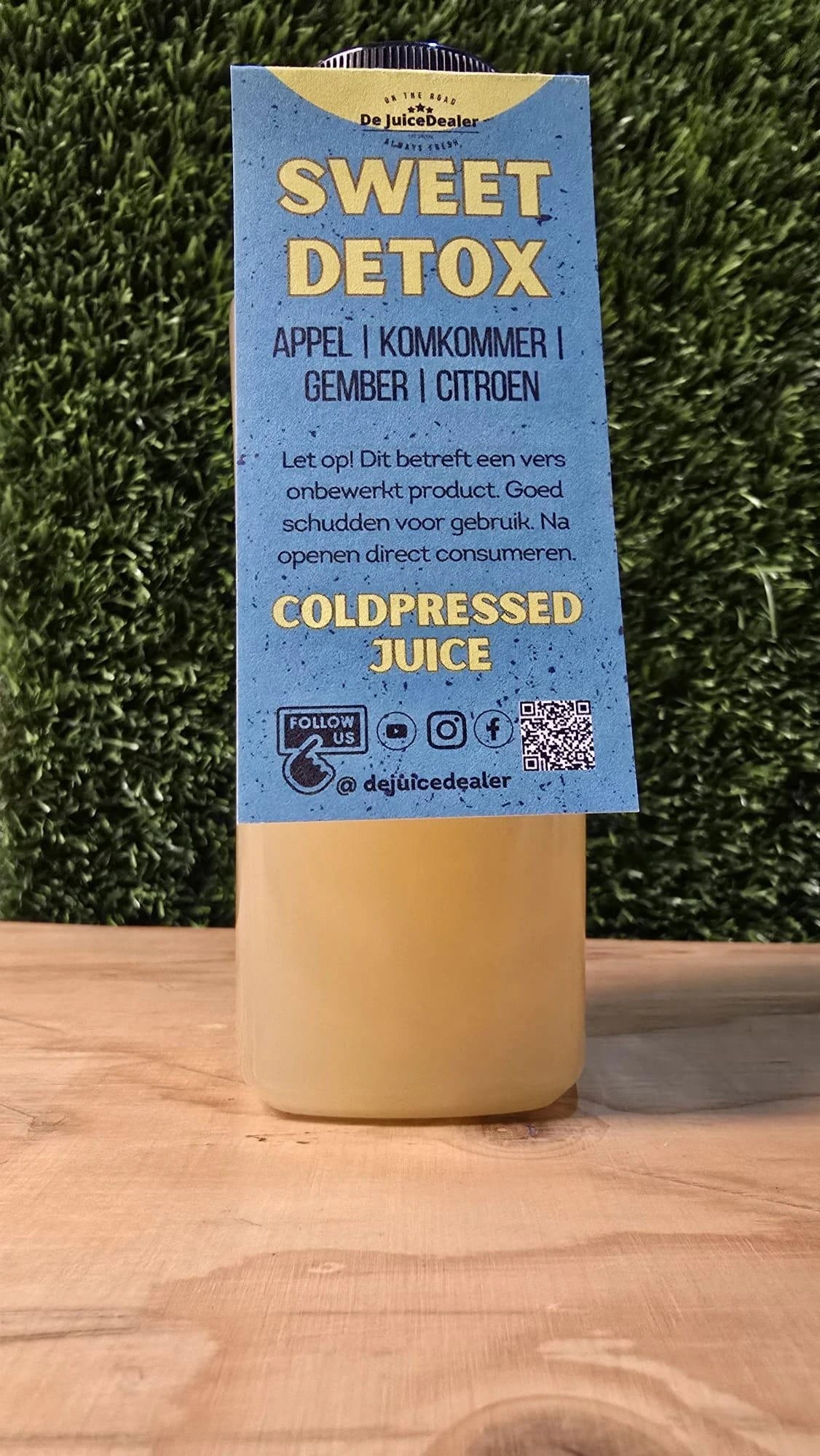 "Sweet Detox cold-pressed juice fles met label van De JuiceDealer, met ingrediënten appel, komkommer, gember en citroen."